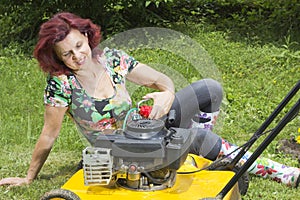 Woman oiling lawn mover