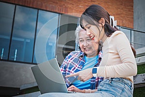 woman old age and young sitting on the stairs, they are happiness to review the lesson together