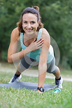 Woman in one armed plank position in park