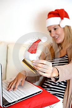 Woman online Christmas shopping with computer and credit card