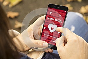 Woman with online dating phone in the park