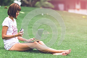 Woman online shopping concept. Woman in the green park with modern laptop. Bali island.