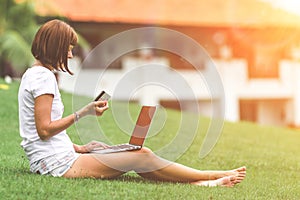 Woman online shopping concept. Woman in the green park with modern laptop. Bali island.