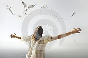 Woman with open arms towards the sky breathes an air of freedom