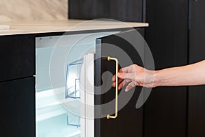 Woman open empthy mini refrigerator indoors, closeup