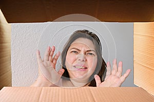 Woman opened a cardboard box with an ordered product and emotionally reacts to its contents, the concept of a postal item, a