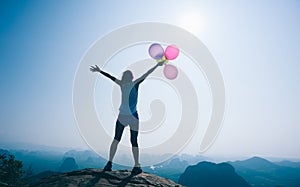Woman opening arms with balloons