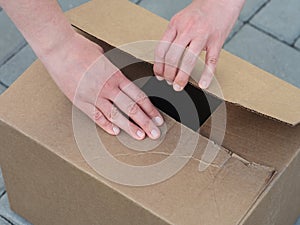 A woman opening a cardboard box