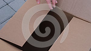 A woman opening a cardboard box.