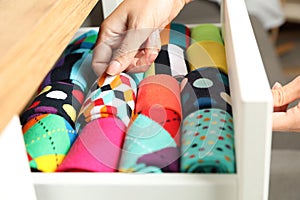 Woman opening drawer with different colorful socks