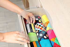 Woman opening drawer with different colorful socks