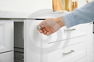 Woman opening drawer in kitchen, closeup view