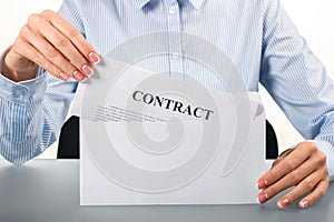 Woman opening envelope with contract.