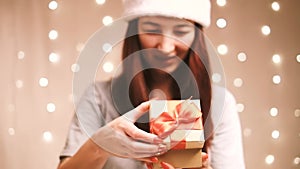Woman opening a gift box and smiling.