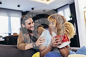 Woman opening a present her boyfriend bought her for their anniversary