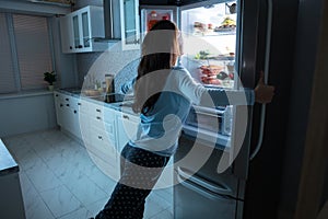 Woman Opening Refrigerator Door photo