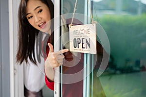 Woman opening store with sign board front door shop for service customer, Small business turning again