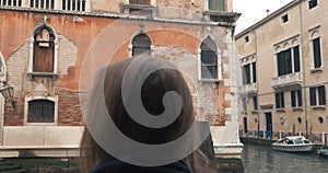 Woman opening window and enjoying Venice scenes