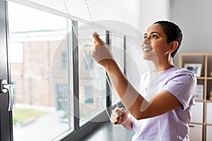 Woman opening window roller blinds