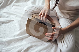 A woman opens a cardboard box.