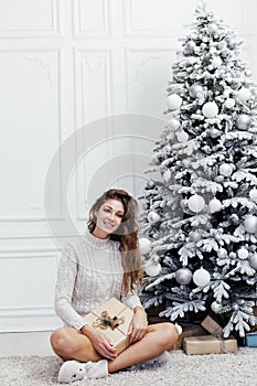 Woman opens Christmas tree gift with gift lights garlands new year