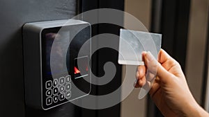 A woman opens the door with a plastic card. Modern keyless entry lock. photo