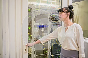 The woman opens the glass door into the server room. Manager enters the modern data center