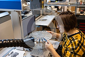 Woman operating a machine that prints logos on pens