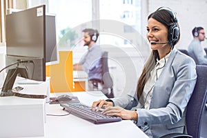 Woman operator agent with headset responding to client& x27;s messages during online chat at customer support department