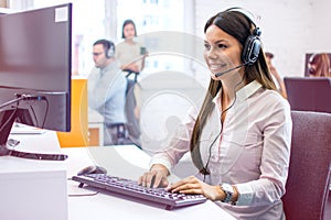 Woman operator working on computer in customer support agency. Helpdesk, tech support, online services and sales concept