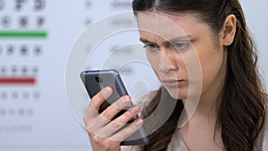 Woman in ophthalmology clinic checking diagnosis through internet, online doctor