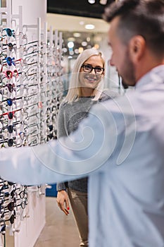 Woman and optician choosing glasses