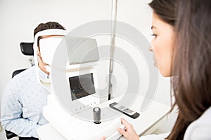 Woman optometrist using tonometer checking patients eyesight