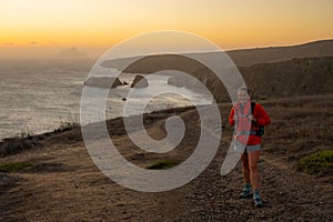 Woman In Orange Coat Stands On Trail Over The Santa Cruz Island Cliffs