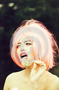 Woman with orange hair lick lollipop