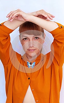 Woman in orange holding arms like butterfly