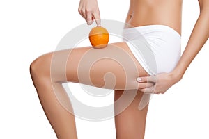 Woman with an orange showing a perfect skin photo