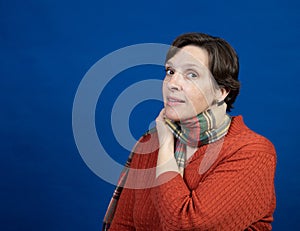 Woman in orange sweater in studio photo