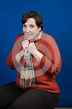 Woman in orange sweater in studio photo