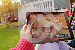 Woman is ordering food on the internet using an app, restaurant meals delivery online