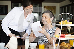 Woman ordering from a menu at restaurant photo