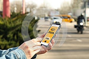 Woman ordering taxi with smartphone on city street