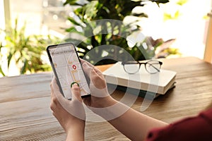 Woman ordering taxi with smartphone at table, closeup