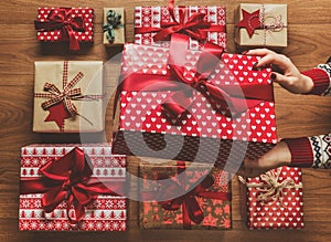 Woman organising beautifully wrapped vintage christmas presents, image with haze, view from above