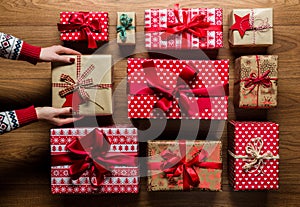 Woman organising beautifuly wrapped vintage christmas presents on wooden background