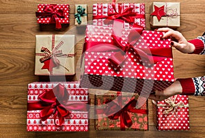 Woman organising beautifuly wrapped vintage christmas presents on wooden background photo