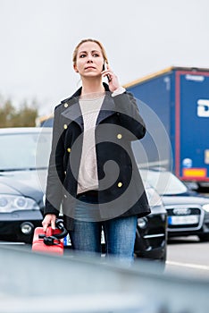 Woman out of gas with her car phoning for somebody to pick her up