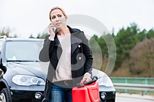 Woman out of gas with her car phoning for somebody to pick her up