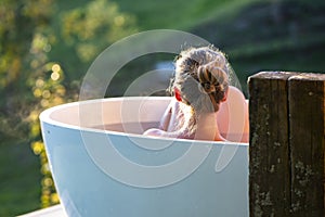 Woman in outdoor bath watching sunset