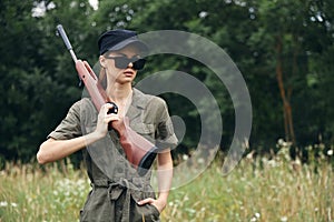 Woman on outdoor Hunting walk with weapons in dark glasses weapons